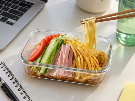 Gekochte Ramen-Nudeln werden im Sieb kalt abgeschreckt, Zubereitung von Hiyashi Chuka als asiatischer Nudelsalat.