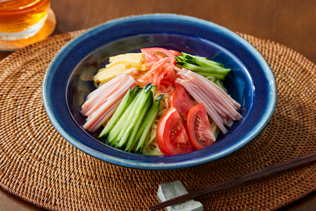 Kaltes erfrischendes Hiyashi Ramen Gericht mit RamenStar  Ramen Nudeln, mit Tomate, Schinken, Gurke und Omelette garniert