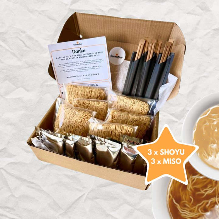 Geoeffnete Kartonbox mit 6 einzeln verpackten weichen Ramennudeln und Ramensuppen dazu 6 Paar Holzstäbchen. Davon sind 3 mit Shoyu Geschmack und 3 mit Miso Geschmack mit Anleitung zum selber zu Hause kochen. 