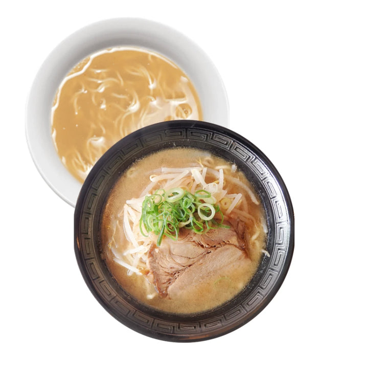 Eine dampfende Schale japanischer MISO-Ramen-Nudelsuppe mit reichhaltiger Brühe, garniert mit saftigem Chashu-Schweinefleisch, knackigen Bohnensprossen und frischen Frühlingszwiebeln. Eine zweite Schale mit hellerer Brühe ist im Hintergrund zu sehen, was die Vielfalt japanischer Gerichte unterstreicht.
