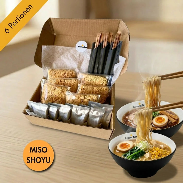 Eine offene braune Kartonschachtel mit 6 einzelnen Packungen Ramen-Nudeln und 6 silbernen Sosenbeuteln. Rechts in der Schachtel stehen mehrere dunkle Essstäbchen. Im Vordergrund befinden sich zwei schwarze Ramen-Schalen. Aus der oberen Schale, die dunkle Brühe, Schweinefleisch, ein halbes Ei und Bambussprossen enthält, werden Nudeln mit Essstäbchen hochgehoben. Aus der unteren Schale, die helle Brühe, Mais, Tofuwürfel, grünes Gemüse und ein halbes Ei enthält, werden ebenfalls Nudeln mit  hochgehoben