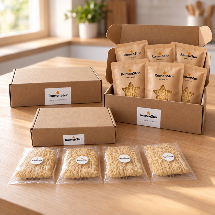 Zwei RamenStar 6er-Boxen, eine geöffnet mit Ramen-Kits und eine geschlossen, sowie eine kleinere Box mit vier einzeln verpackten Nudelportionen.