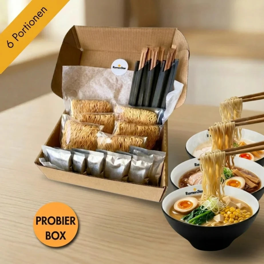 RamenStar Probierbox mit sechs Portionen japanischer Ramen-Nudeln und Zutaten in einer offenen Box. Drei Schalen fertig zubereiteter Ramen mit Ei, Mais und Gemüse sind daneben, Essstäbchen heben Nudeln.