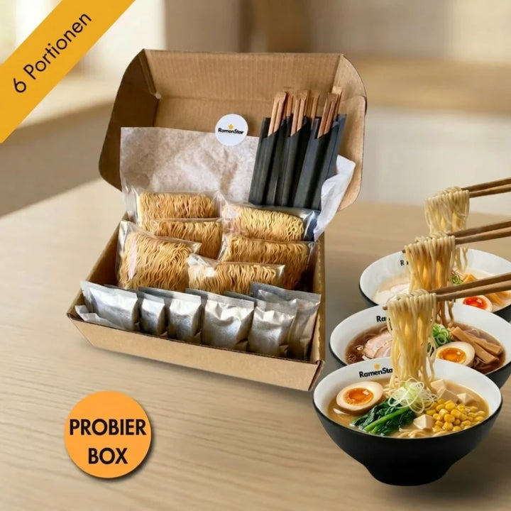 RamenStar Probierbox mit sechs Portionen japanischer Ramen-Nudeln und Zutaten in einer offenen Box. Drei Schalen fertig zubereiteter Ramen mit Ei, Mais und Gemüse sind daneben, Essstäbchen heben Nudeln.