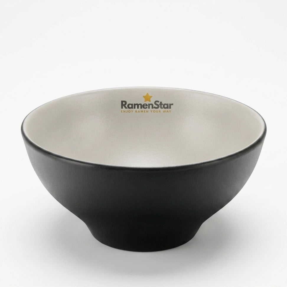Eine stilvolle, matte schwarze Ramen-Schale von RamenStar, innen hellbeige, perfekt für authentischen Ramen-Genuss. Das Markenlogo mit goldenem Stern ziert den oberen Rand dieser hochwertigen japanischen Nudelschale.