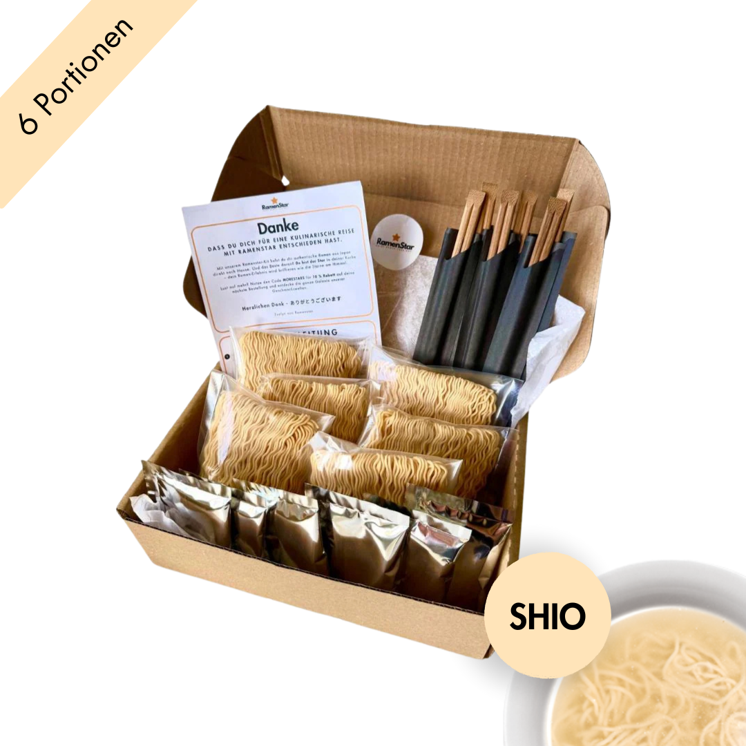 Abgebildet ist eine Probierbox von RamenStar mit sechs Portionen Shio-Ramen in einer umweltfreundlichen Kartonverpackung. Die Inhalte – Nudeln, Suppenbasis und Stäbchen – sind ordentlich in Seidenpapier eingelegt, begleitet von einer Begrüßungskarte. Rechts unten weist ein runder Button mit „SHIO“ auf den enthaltenen Salzgeschmack hin. Die helle Brühe wirkt leicht und aromatisch.