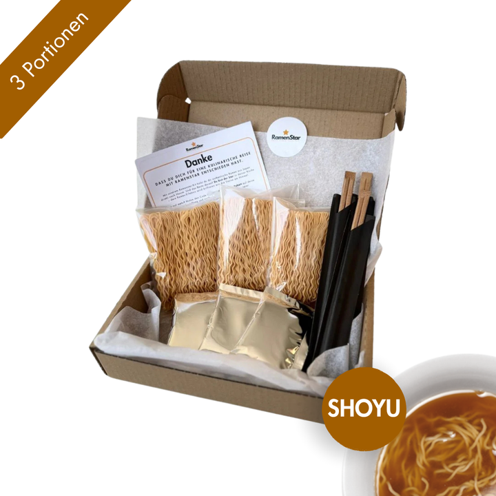 Das Bild zeigt eine Shoyu-Ramen-Box von RamenStar für drei Portionen, stilvoll verpackt in einer offenen Kartonbox. Enthalten sind drei Bündel Ramen-Nudeln, drei Suppenbeutel in Silberverpackung, drei Paar Stäbchen und eine Dankeskarte. Unten rechts weist ein brauner Kreis mit der Aufschrift „SHOYU“ und ein Bild einer dunklen Sojasaucen-Brühe auf den Geschmack hin. Ein ideales Set für Liebhaber klassischer japanischer Ramen.